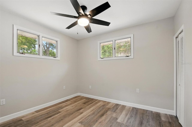 unfurnished bedroom with a closet, baseboards, and multiple windows