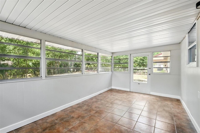 unfurnished sunroom featuring baseboards and tile patterned flooring