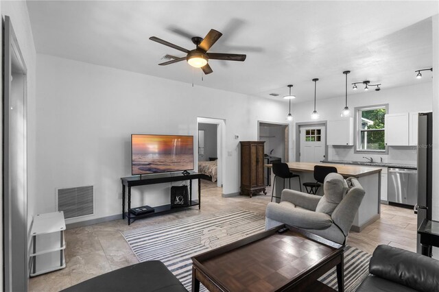 living area with visible vents and ceiling fan