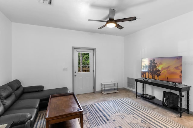 living room with baseboards, a ceiling fan, and visible vents