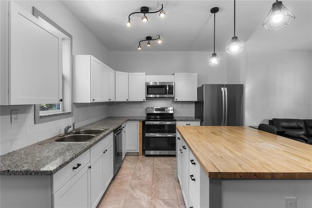 kitchen featuring a sink, wood counters, tasteful backsplash, and stainless steel appliances
