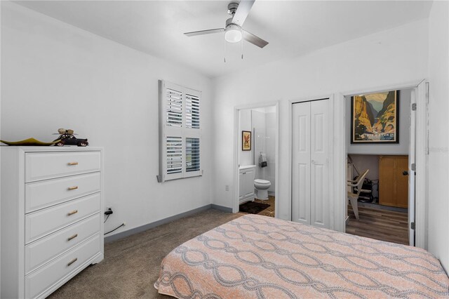 bedroom with a closet, dark carpet, baseboards, ensuite bathroom, and ceiling fan
