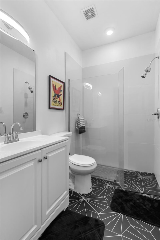 bathroom featuring a walk in shower, vanity, toilet, and visible vents