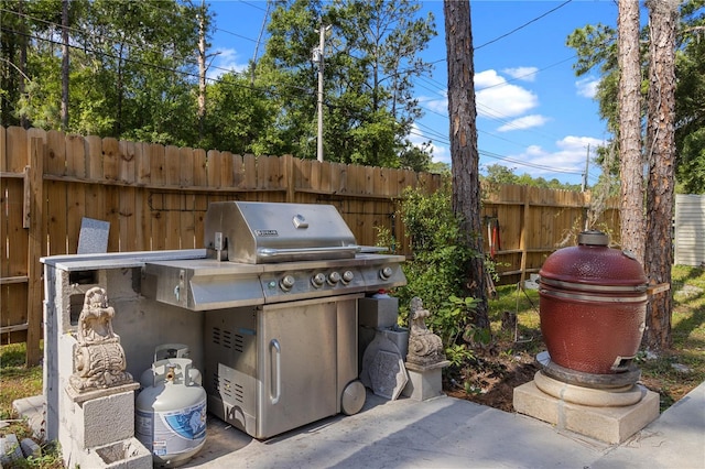 view of patio with area for grilling and fence