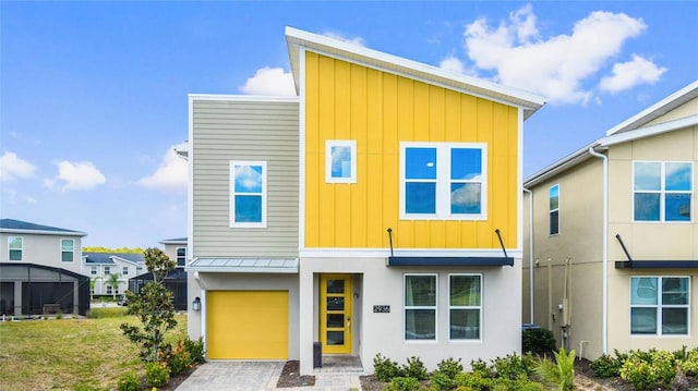 2936 Protagonist St, Kissimmee, FL 34746 - contemporary home with board and batten siding, a standing seam roof, driveway, metal roof, and an attached garage