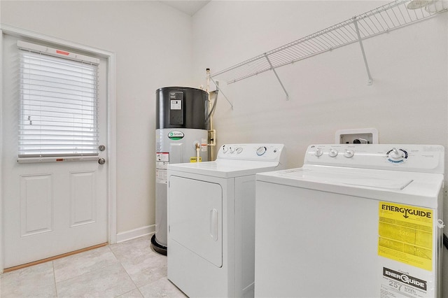 clothes washing area with laundry area, light tile patterned floors, baseboards, water heater, and separate washer and dryer