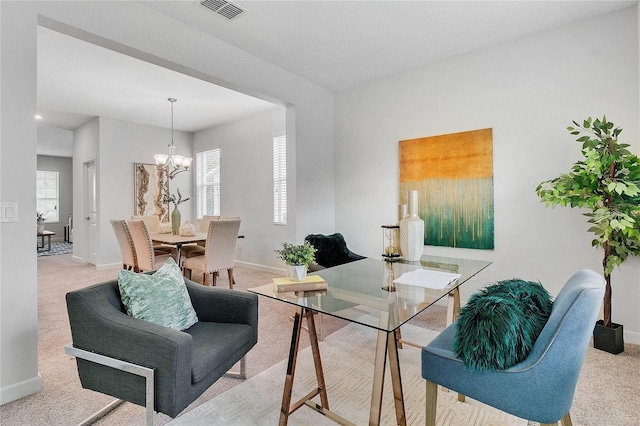 carpeted living room featuring a healthy amount of sunlight, baseboards, a chandelier, and visible vents