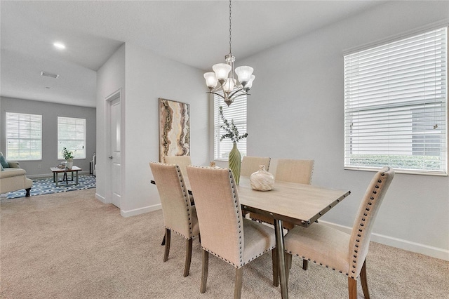 dining area with baseboards, a notable chandelier, light carpet, and visible vents