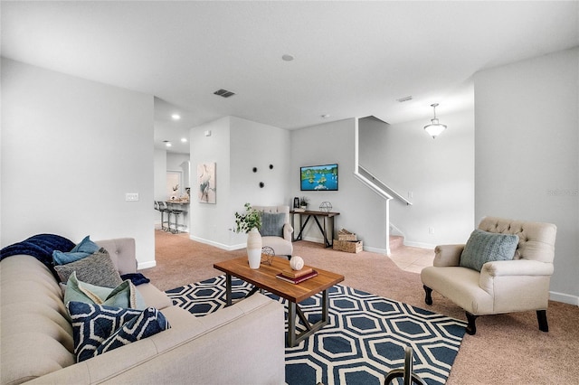 living area with stairway, carpet, and visible vents