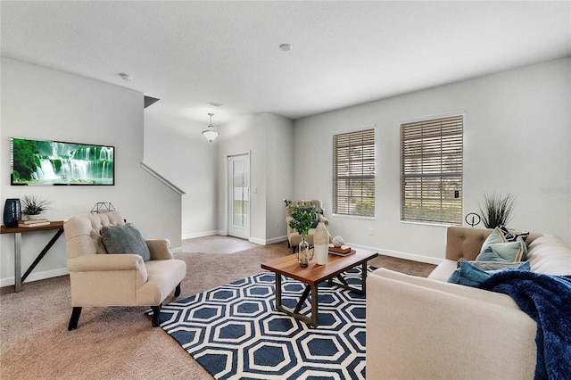 carpeted living area featuring baseboards