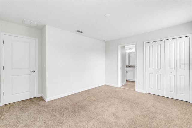 unfurnished bedroom with baseboards, visible vents, carpet, and a closet