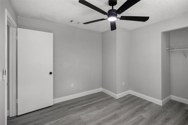 2105 9th St NE, Winter Haven, FL 33880 - unfurnished bedroom with baseboards, visible vents, a textured ceiling, and wood finished floors