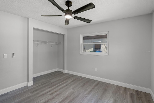 2105 9th St NE, Winter Haven, FL 33880 - unfurnished bedroom with a closet, a textured ceiling, wood finished floors, and baseboards