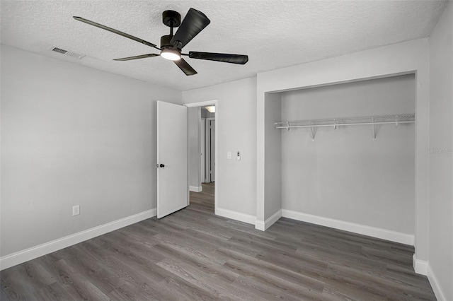 2105 9th St NE, Winter Haven, FL 33880 - unfurnished bedroom with dark wood-style flooring, a textured ceiling, a closet, baseboards, and a ceiling fan
