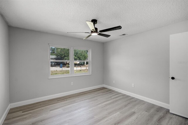 2105 9th St NE, Winter Haven, FL 33880 - empty room featuring a textured ceiling, light wood-style flooring, a ceiling fan, and baseboards