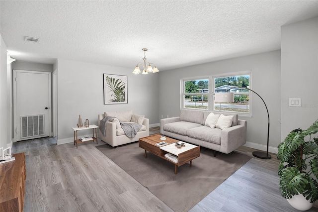 2105 9th St NE, Winter Haven, FL 33880 - living area featuring wood finished floors, a textured ceiling, baseboards, and a chandelier