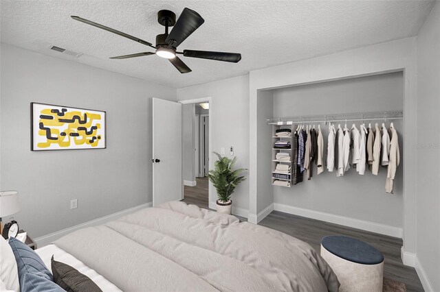 2105 9th St NE, Winter Haven, FL 33880 - bedroom featuring wood finished floors, a textured ceiling, a closet, a ceiling fan, and baseboards