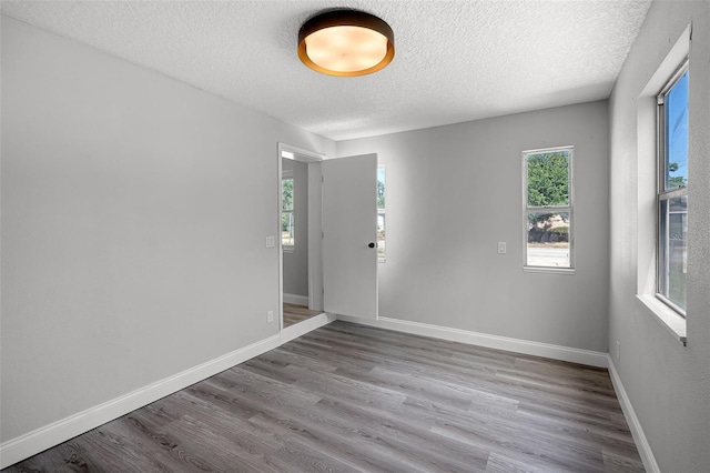 2105 9th St NE, Winter Haven, FL 33880 - empty room with a textured ceiling, wood finished floors, and baseboards