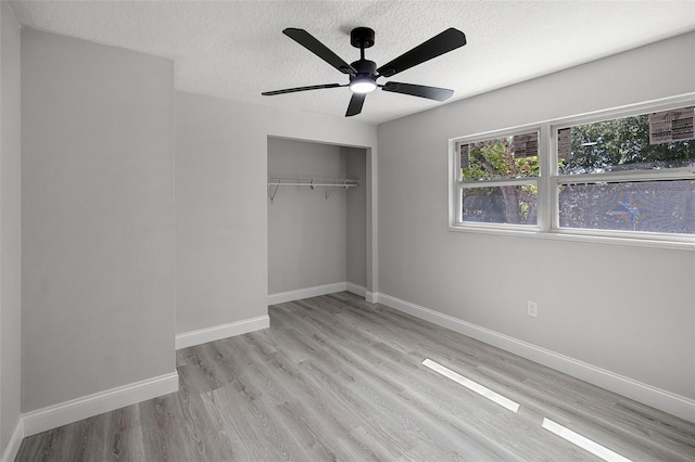2105 9th St NE, Winter Haven, FL 33880 - unfurnished bedroom with a closet, a textured ceiling, wood finished floors, and baseboards