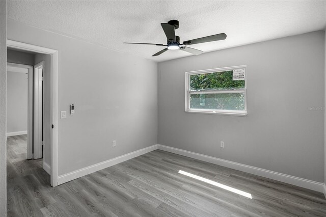 2105 9th St NE, Winter Haven, FL 33880 - spare room with wood finished floors, ceiling fan, a textured ceiling, and baseboards