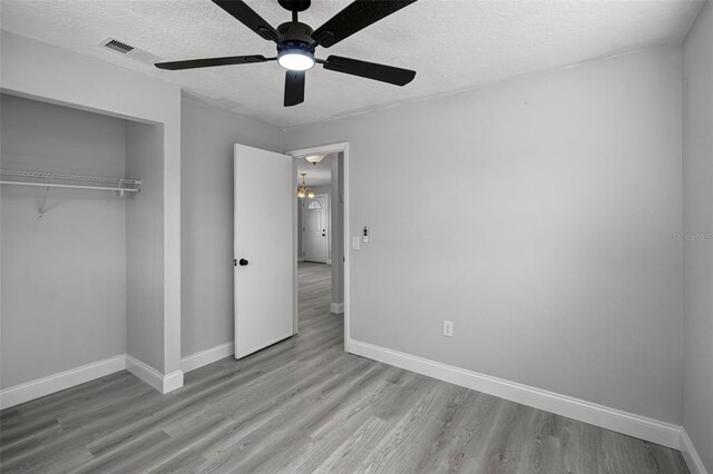 2105 9th St NE, Winter Haven, FL 33880 - unfurnished bedroom featuring baseboards, wood finished floors, a textured ceiling, and a closet