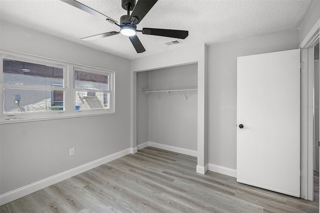 2105 9th St NE, Winter Haven, FL 33880 - unfurnished bedroom with wood finished floors, a closet, a textured ceiling, visible vents, and baseboards