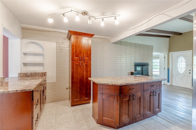 1108 Gibson St, Leesburg, FL 34748 - kitchen with light tile patterned flooring, light stone counters, open shelves, a center island, and crown molding