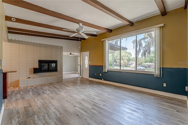 1108 Gibson St, Leesburg, FL 34748 - unfurnished living room featuring beamed ceiling, ceiling fan, healthy amount of natural light, and wood finished floors