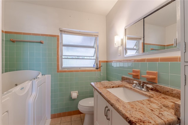 1108 Gibson St, Leesburg, FL 34748 - bathroom with tile walls, tile patterned flooring, a tub with jets, healthy amount of natural light, and a wainscoted wall