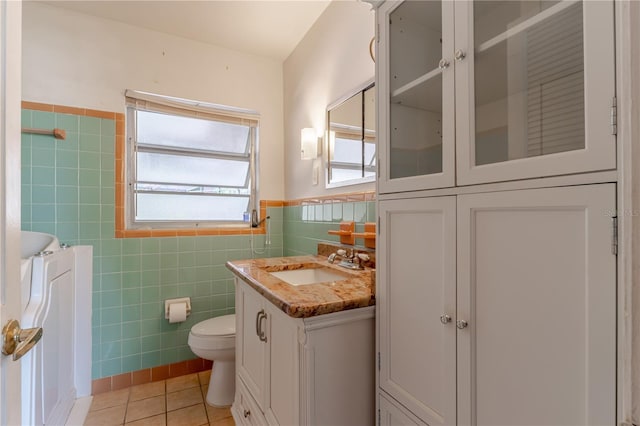1108 Gibson St, Leesburg, FL 34748 - bathroom with tile walls, tile patterned floors, toilet, vanity, and wainscoting