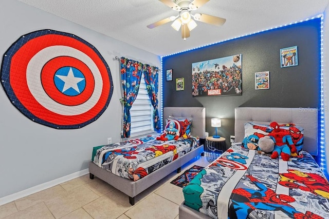 tiled bedroom featuring a ceiling fan, a textured ceiling, and baseboards