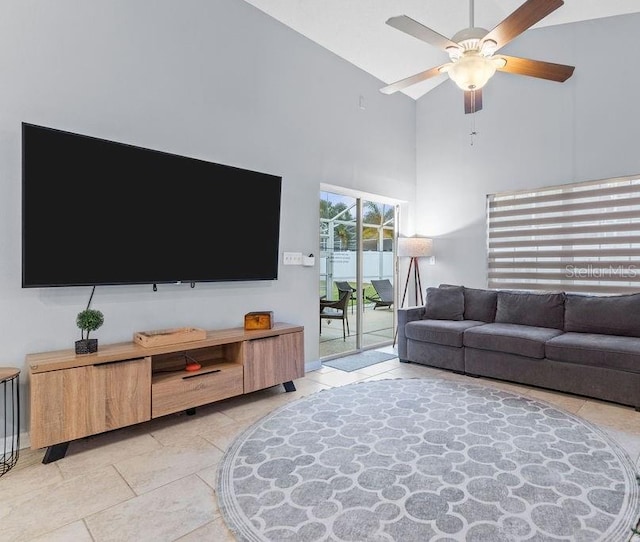 living room with a ceiling fan, light tile patterned floors, and a towering ceiling