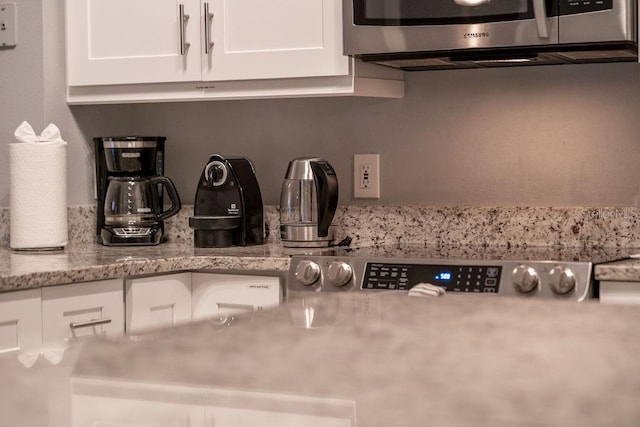 kitchen with white cabinetry and stainless steel microwave