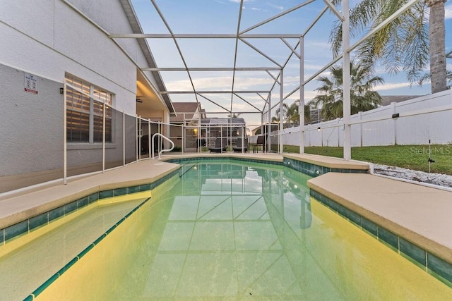 view of swimming pool featuring glass enclosure, fence, a patio area, and a fenced in pool