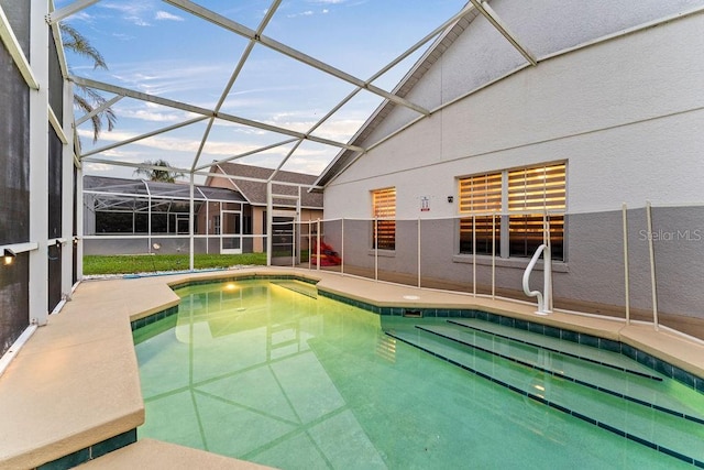 outdoor pool with glass enclosure and a patio area