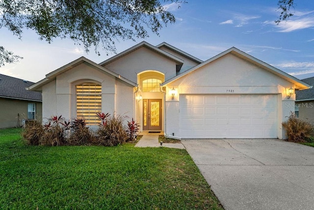ranch-style home with concrete driveway, stucco siding, an attached garage, and a front lawn