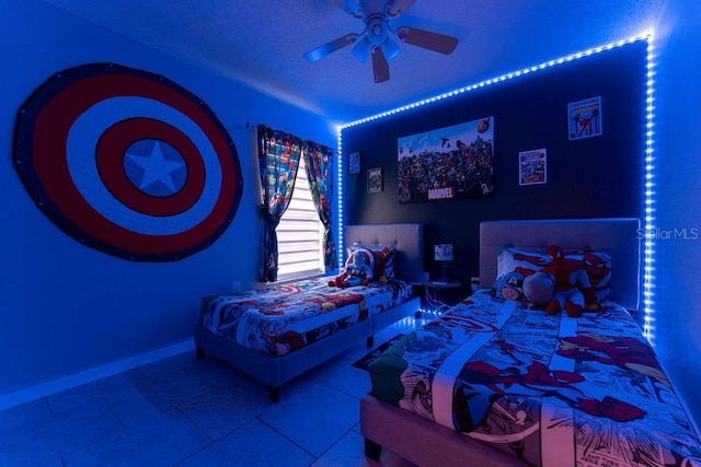 tiled bedroom with baseboards and a ceiling fan