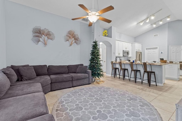 living room featuring arched walkways, a ceiling fan, visible vents, and high vaulted ceiling