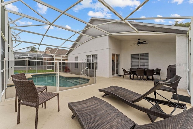 outdoor pool featuring glass enclosure, a patio, and ceiling fan