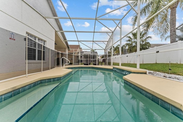 view of swimming pool featuring fence, a fenced in pool, glass enclosure, and a patio