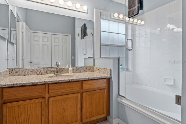 bathroom with bath / shower combo with glass door and vanity