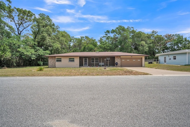 ranch-style house featuring an attached garage, driveway, and a front yard