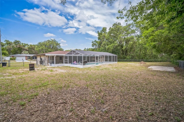 back of house with a fenced backyard, glass enclosure, and a yard