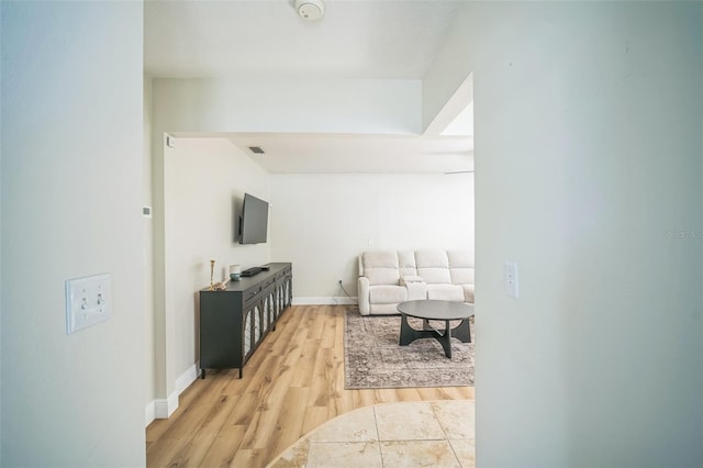 living area with baseboards, visible vents, and light wood-type flooring