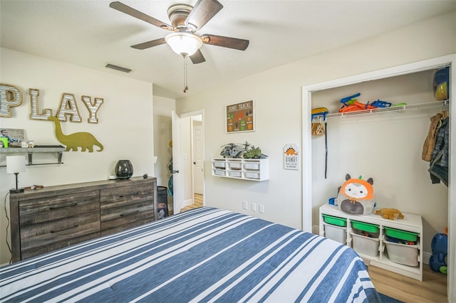 bedroom featuring visible vents, ceiling fan, wood finished floors, and a closet