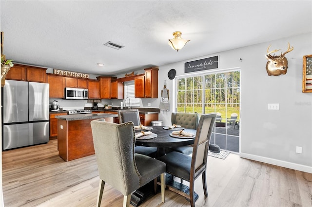 1555 Seminole Run Rd, Osteen, FL 32764 - dining area with visible vents, light wood finished floors, and baseboards