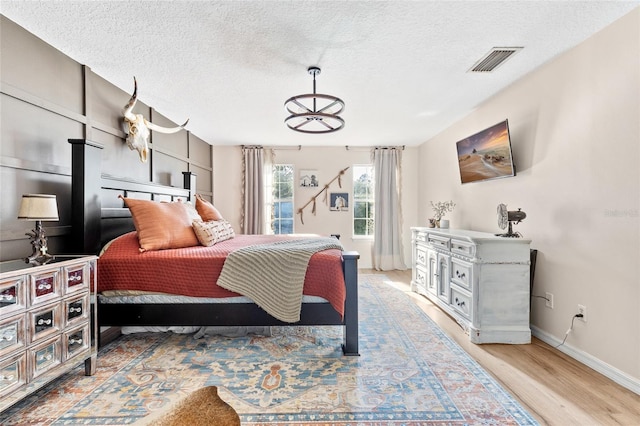 1555 Seminole Run Rd, Osteen, FL 32764 - bedroom featuring a textured ceiling, baseboards, visible vents, and light wood-style floors