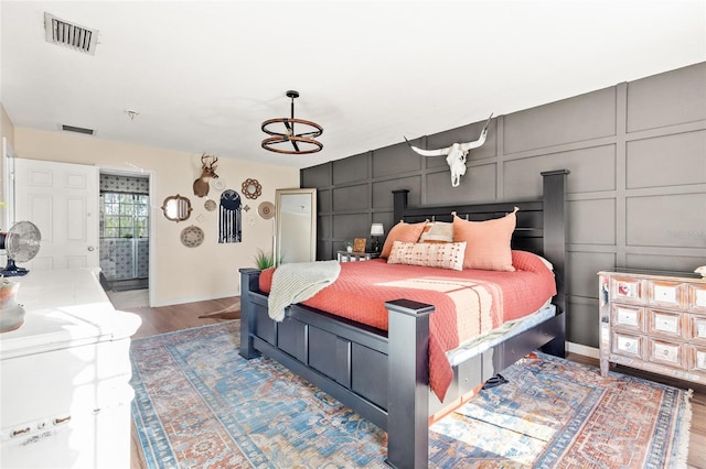 1555 Seminole Run Rd, Osteen, FL 32764 - bedroom with baseboards, a decorative wall, wood finished floors, and visible vents