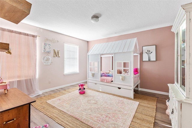 1555 Seminole Run Rd, Osteen, FL 32764 - bedroom with baseboards, a textured ceiling, and light wood finished floors
