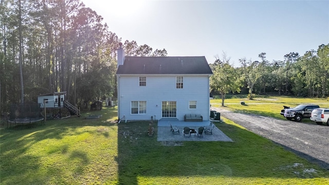 1555 Seminole Run Rd, Osteen, FL 32764 - back of property featuring a patio, a chimney, stairs, a lawn, and a trampoline